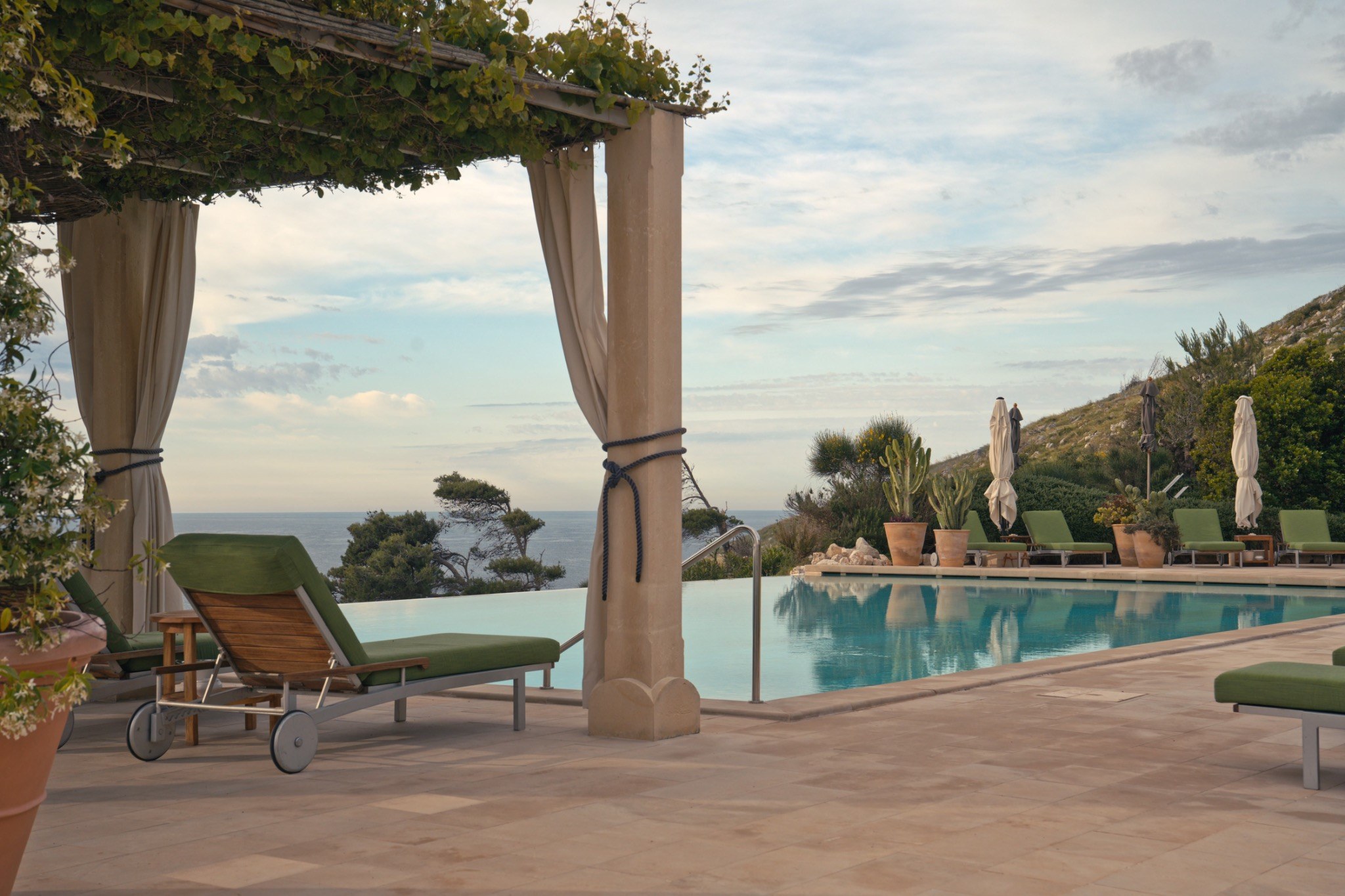 Terrazza con piscina dell'hotel Le Capase affacciata sulla vegetazione mediterranea e sul mare
