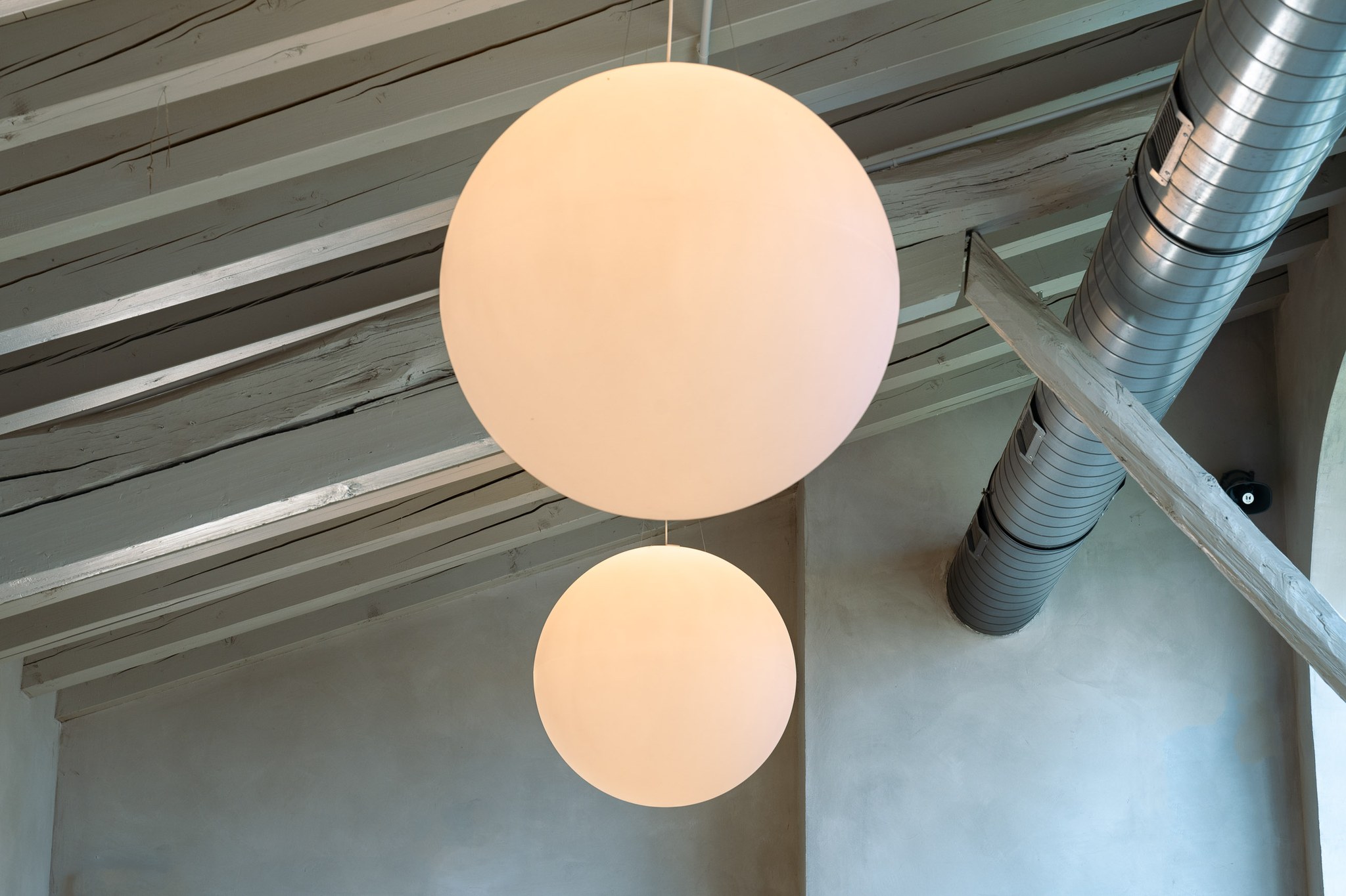 Lampade sferiche e struttura a vista in un interno contemporaneo